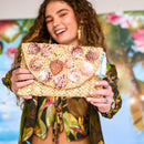 Straw clutch adorned with pink and purple shells