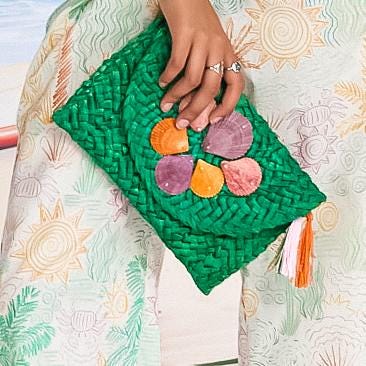 Green straw clutch adorned with pink and purple shells