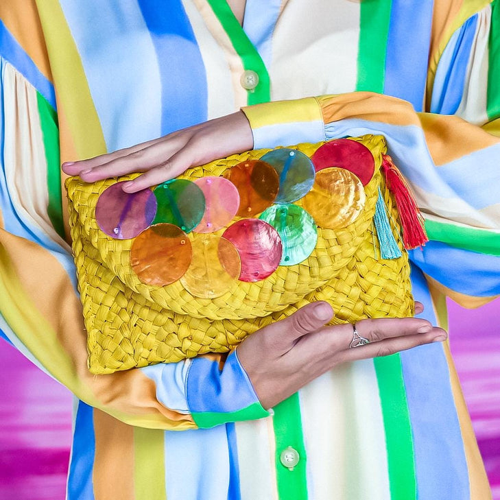 Yellow straw clutch adorned multicolour sea shell discs
